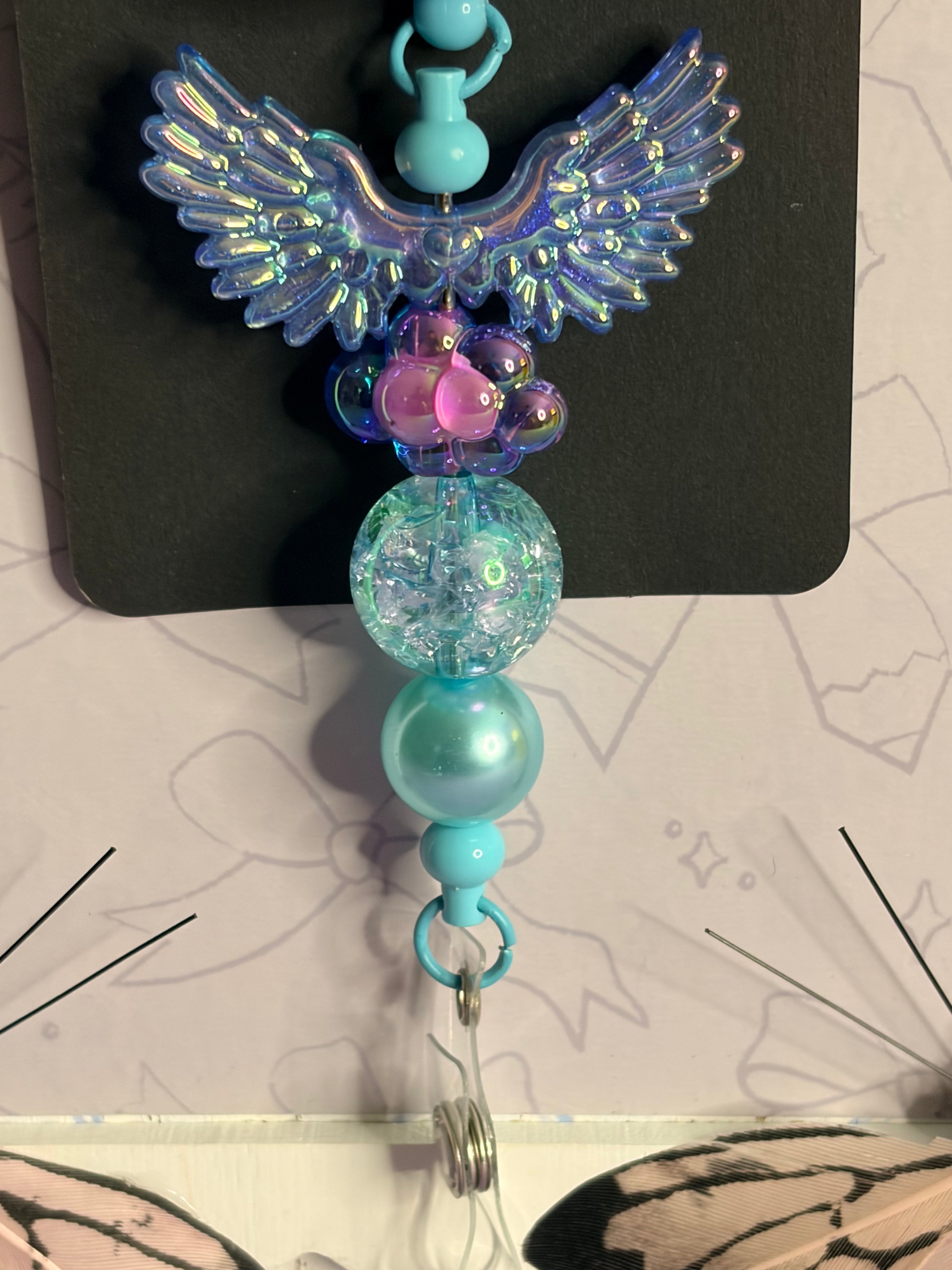 Winter Kawaii Dumpling Badge Reel with Iridescent Angel Wings & Teal Beaded Charm