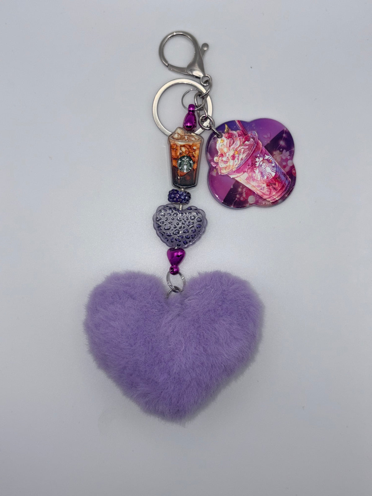 Purple coffee-themed keychain with fluffy lavender heart, spotted heart bead, purple accents, iced-coffee charm, purple drink-design charm, and silver-tone clasp.