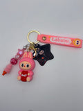 Pink Labubu-themed keychain with pink lettered strap, bunny-eared character holding a red soda can, black star charm, and pink beaded dangle.