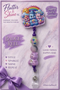 Care Bears themed badge reel with colorful bears beneath a rainbow, sparkling pink-purple border, multicolor and lavender beads, lavender bear-shaped bead, and clear snap badge strap.