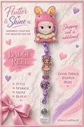 Sonny Angel themed badge reel with pink bunny-eared character topper, purple star-hat character accent, sparkling purple beads, lavender connectors, and clear snap strap.
