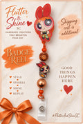 Blossom Themed badge reel with red-bow character topper, smaller Blossom accent, orange textured bead, copper-toned bead, orange accents, and clear snap badge strap.