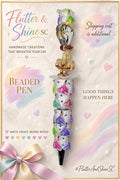 Lumiere and Chip themed beaded pen with smiling teacup and gold-toned candlestick character accents, white dish-shaped detail, pastel princess-decorated barrel, sparkling accents, and dark pointed tip.